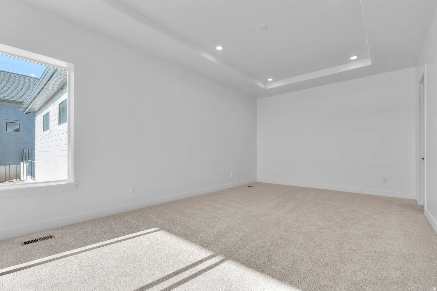 Unfurnished room featuring carpet floors, recessed lighting, and a tray ceiling