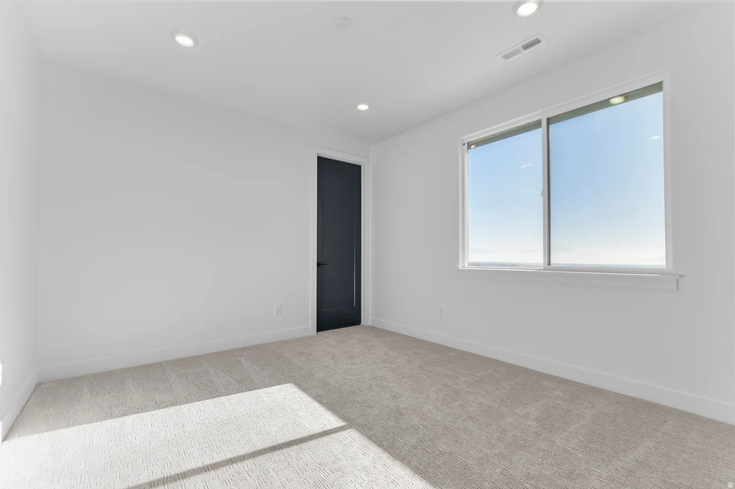 Empty room featuring light colored carpet and recessed lighting