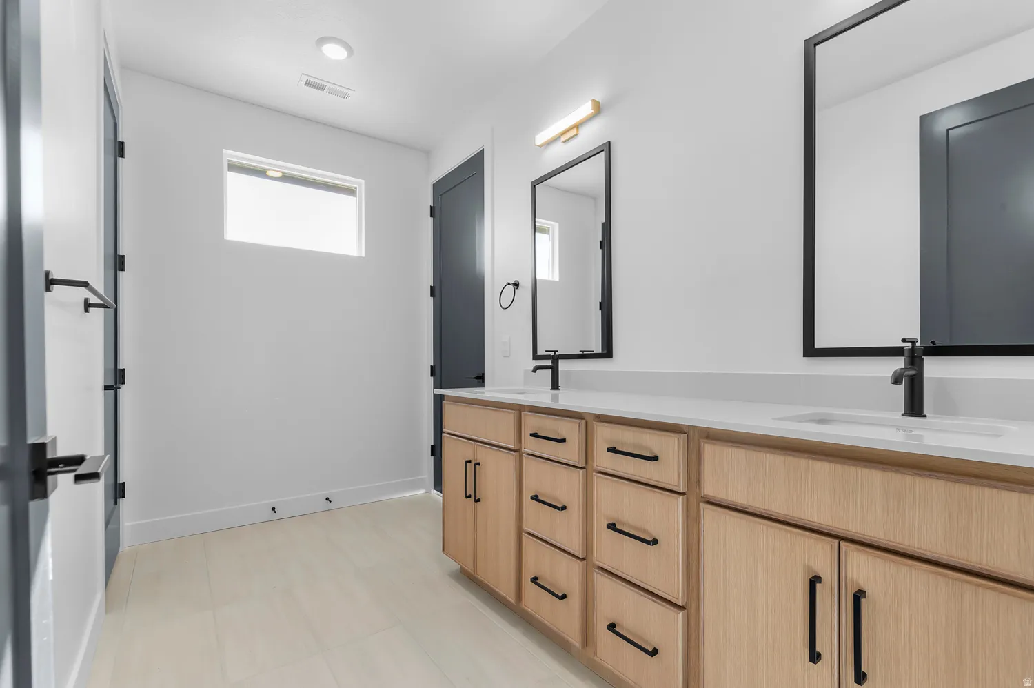 Bathroom featuring double vanity and baseboards