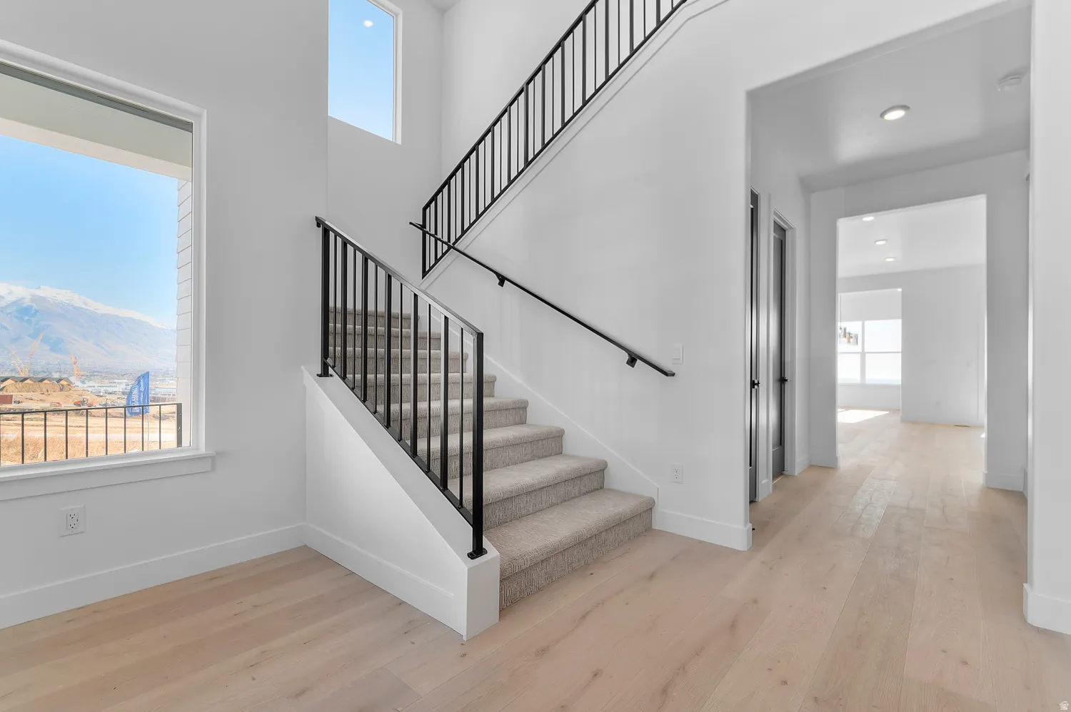 Stairs featuring hardwood / wood-style floors, a mountain view, and a high ceiling