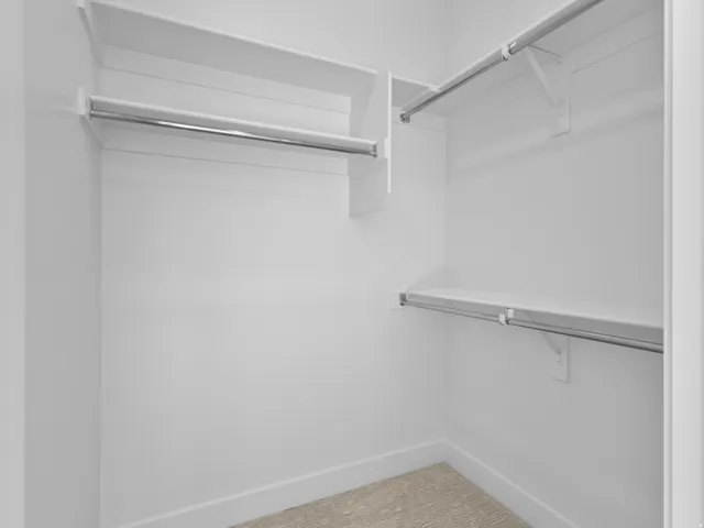 Built-in closet system featuring white shelving and chrome hanging rods