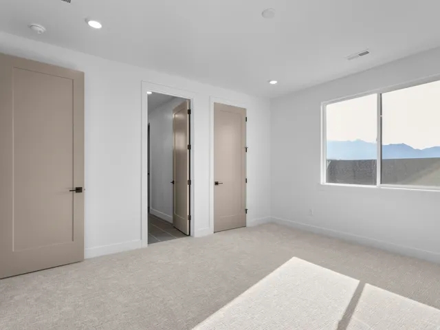 Bright room with neutral-toned carpeting and white walls