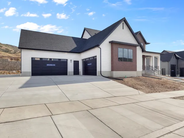 Contemporary-style residence featuring a two-car garage with black doors and transom windows