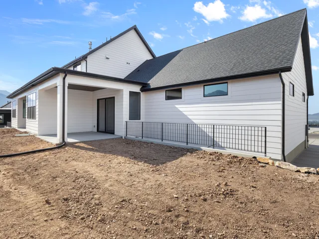 Modern farmhouse exterior showcasing crisp white fiber cement siding, charcoal architectural shingle roofing, and clean-lined gable design