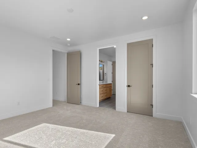Carpeted room with recessed lighting and neutral wall tones