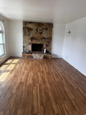 Unfurnished living room featuring wood finished floors and a fireplace