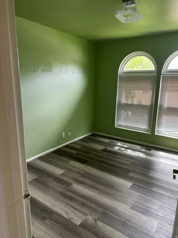 Spare room featuring dark wood-style floors