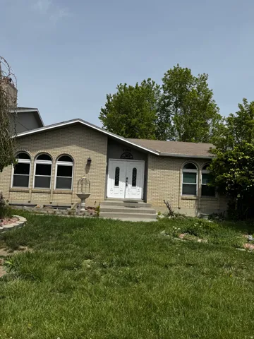 View of front of house featuring a front yard and brick siding