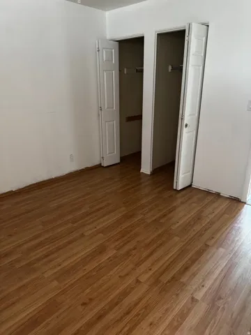 Unfurnished bedroom with wood finished floors