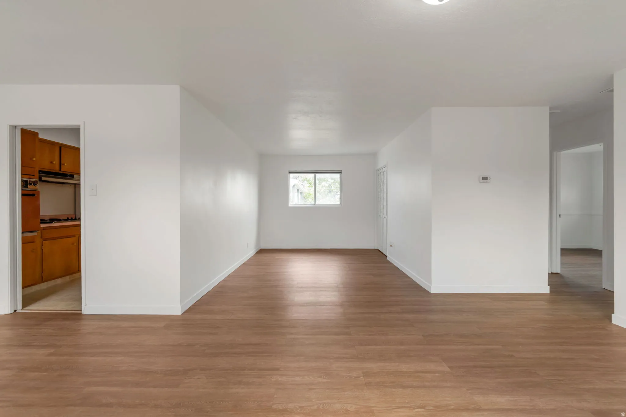 Unfurnished room with light wood finished floors and baseboards