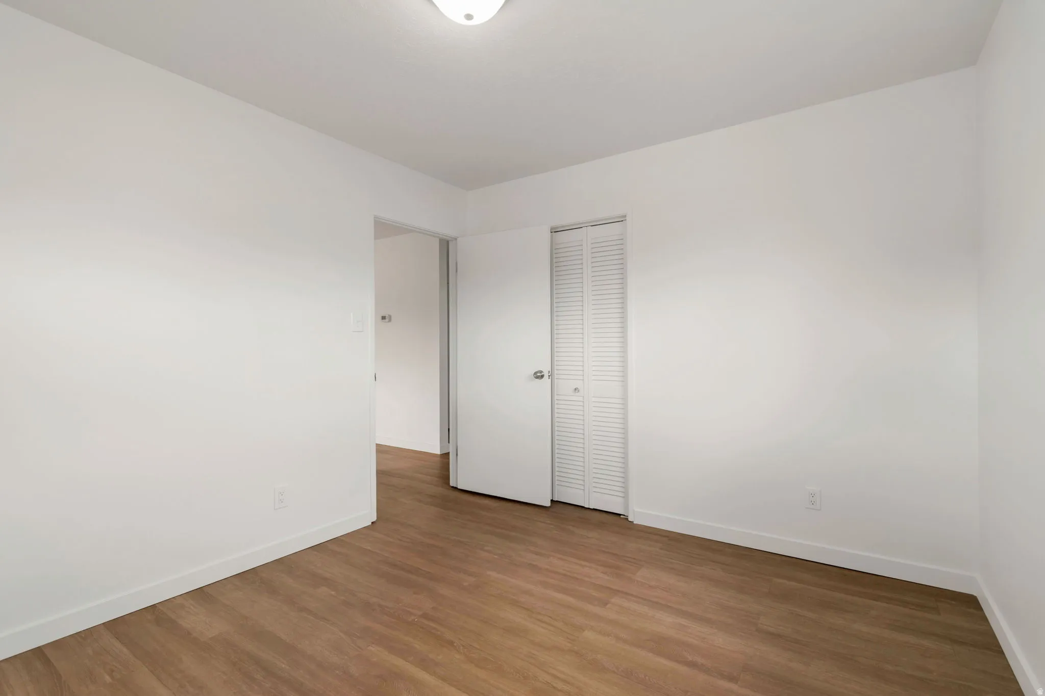 Unfurnished bedroom featuring wood finished floors and a closet