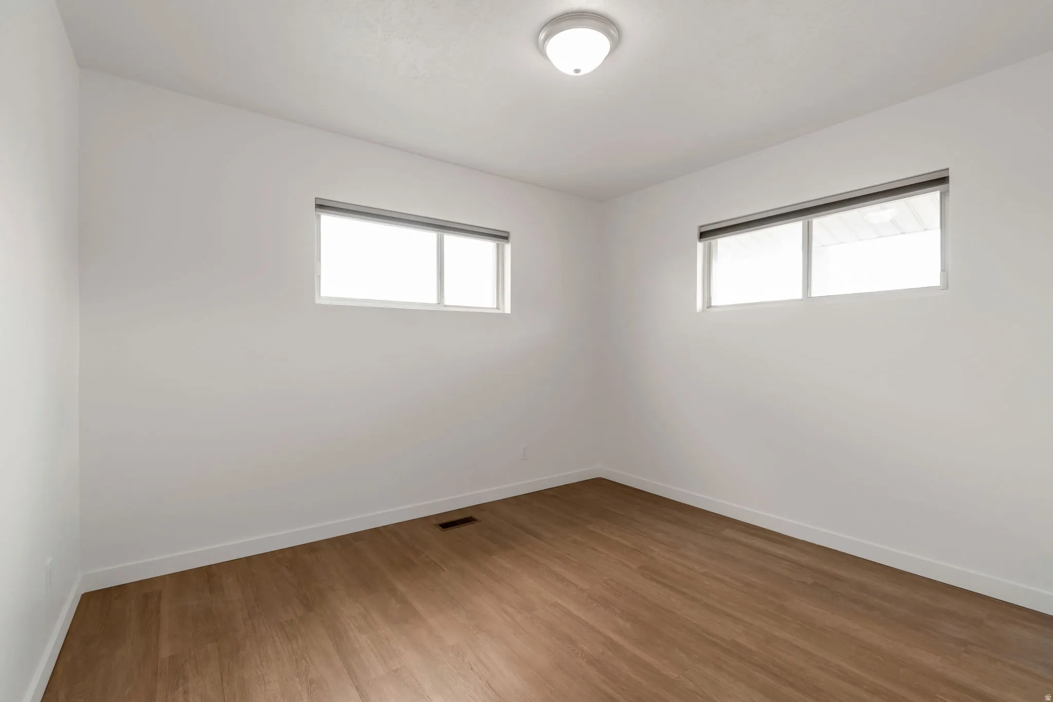 Empty room featuring wood finished floors and plenty of natural light