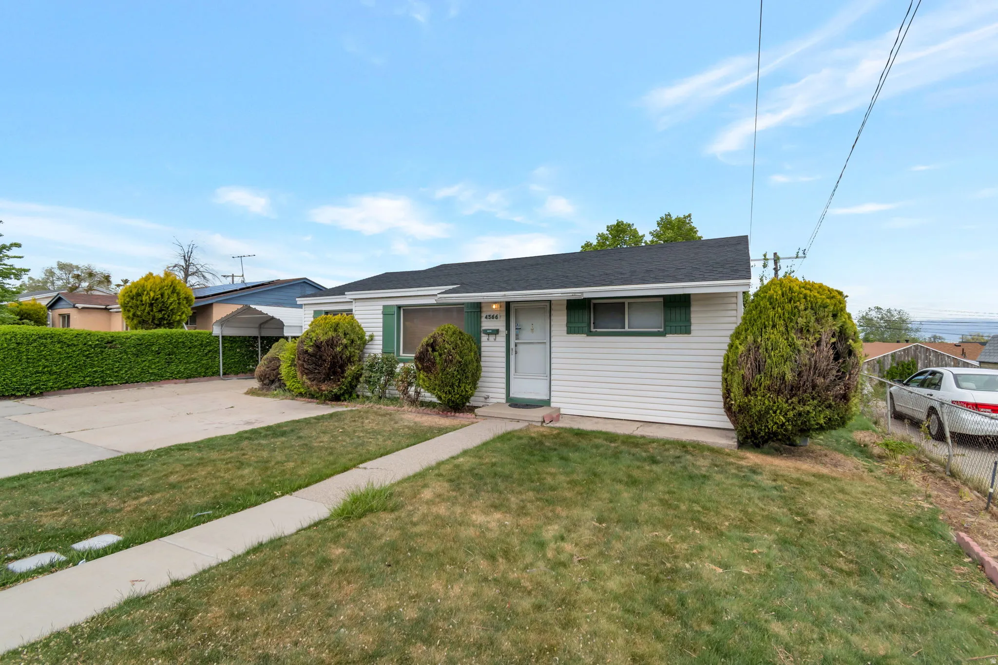 View of front of house with driveway and a detached carport