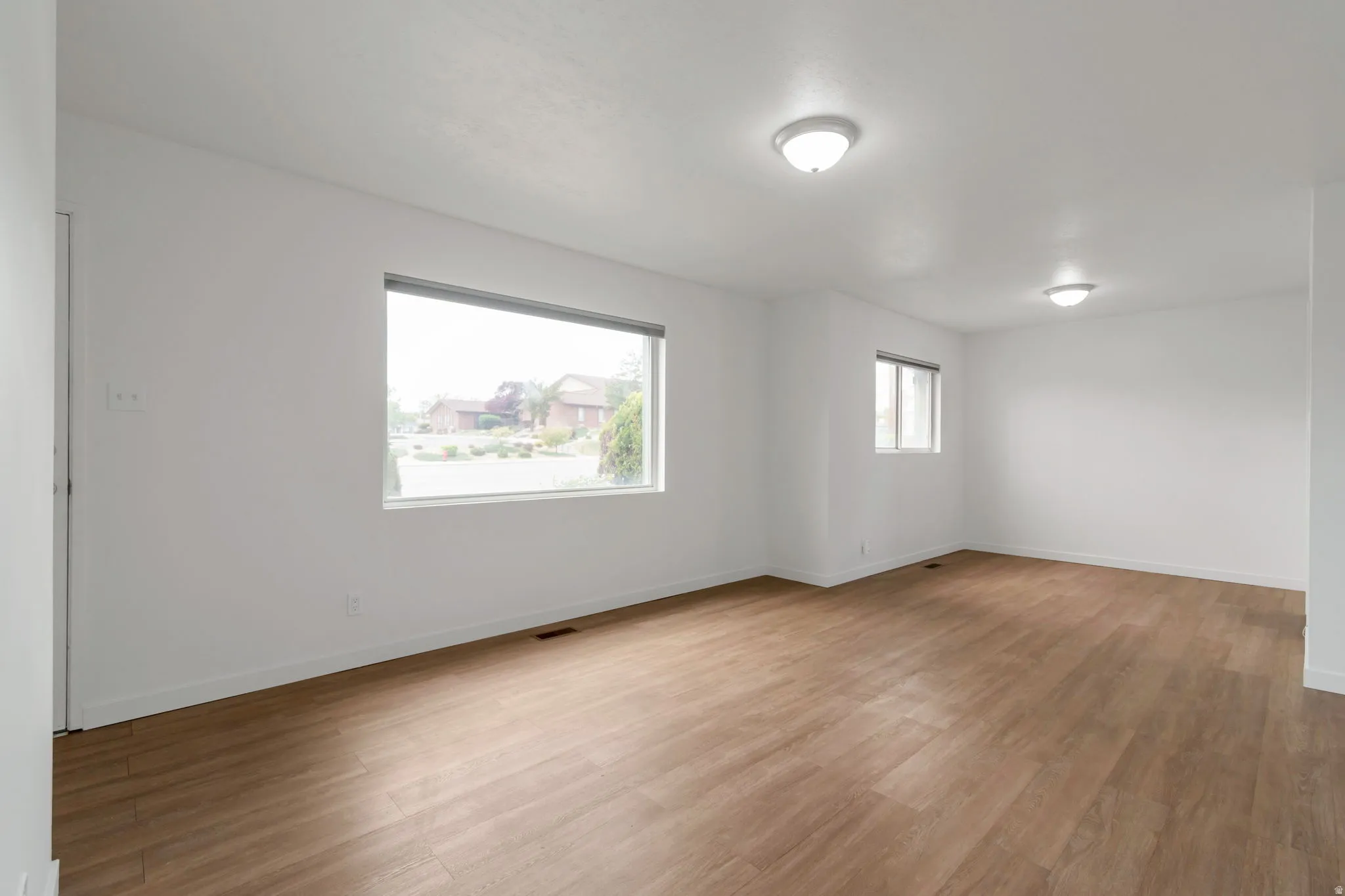 Unfurnished room with light wood-style flooring and baseboards
