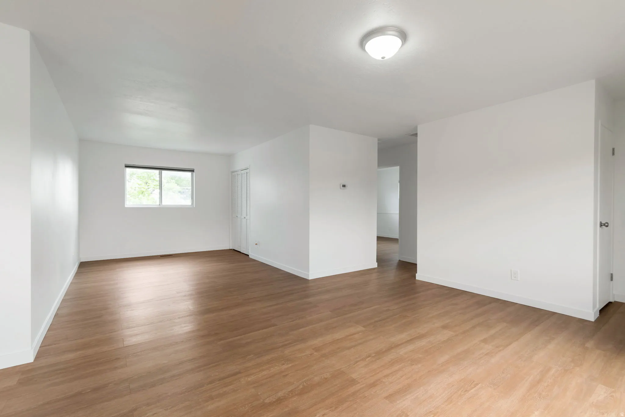 Empty room with light wood finished floors and baseboards