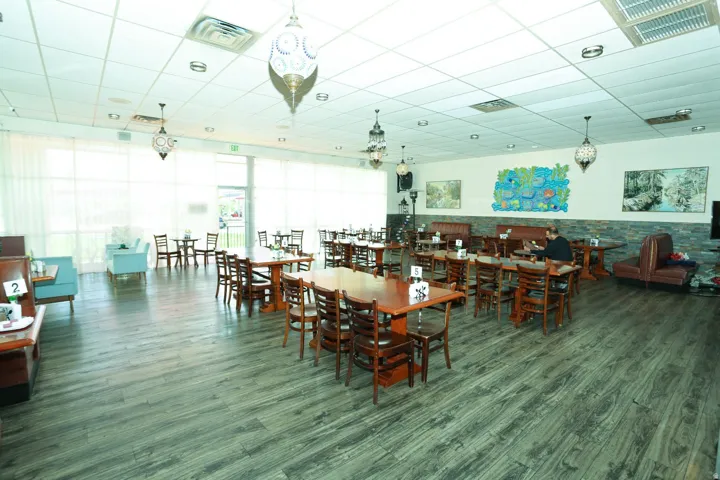 Dining space featuring a drop ceiling and dark wood finished floors