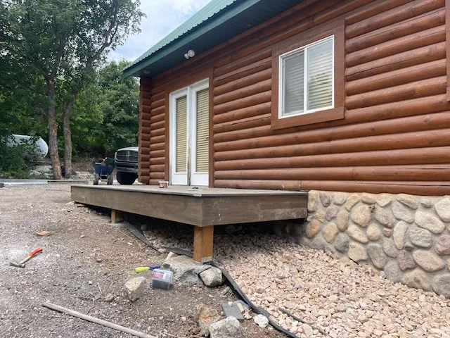 View of home's exterior with a wooden deck, a metal roof, and faux log siding