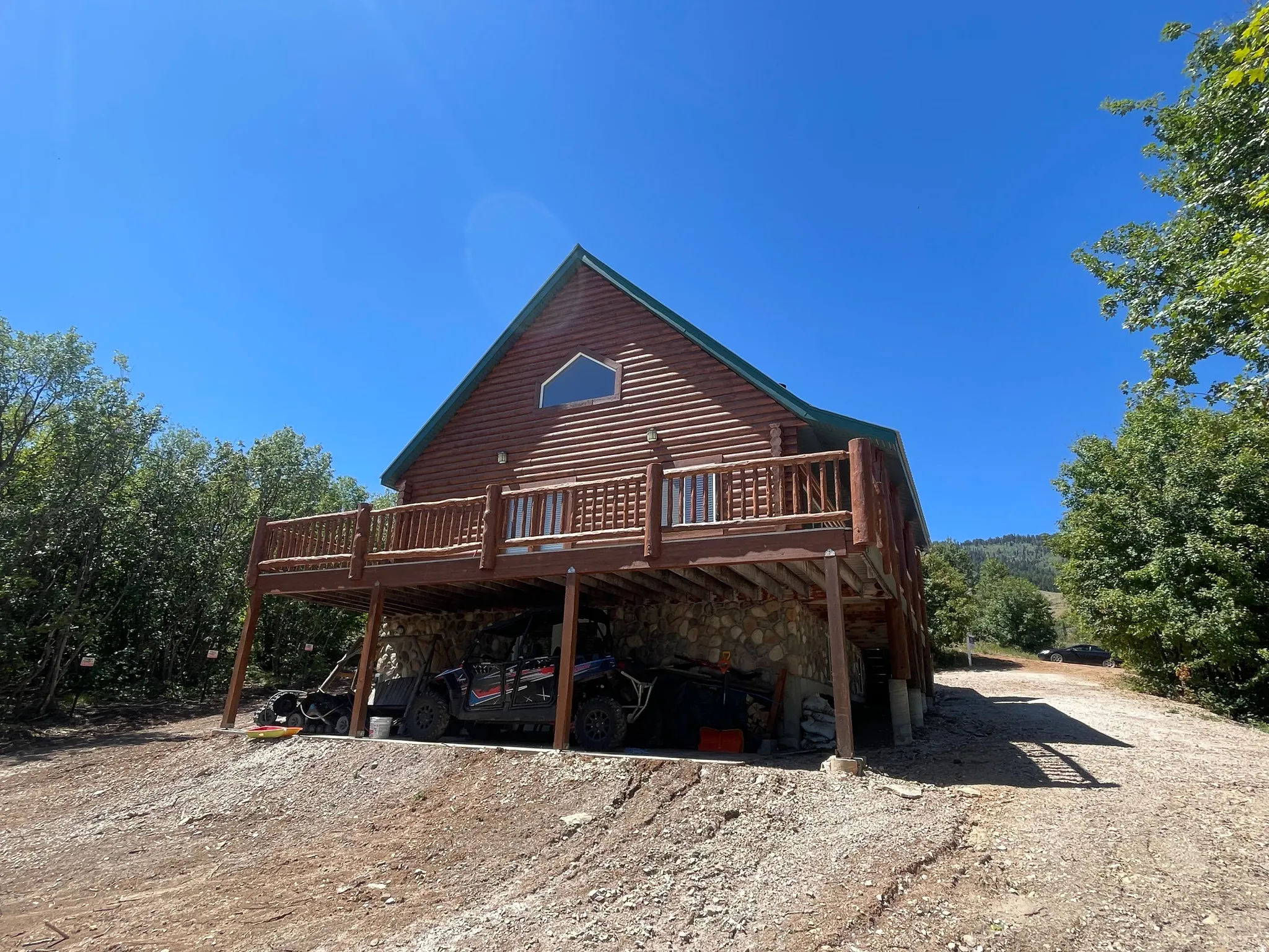 Back of property featuring a wooden deck and log siding
