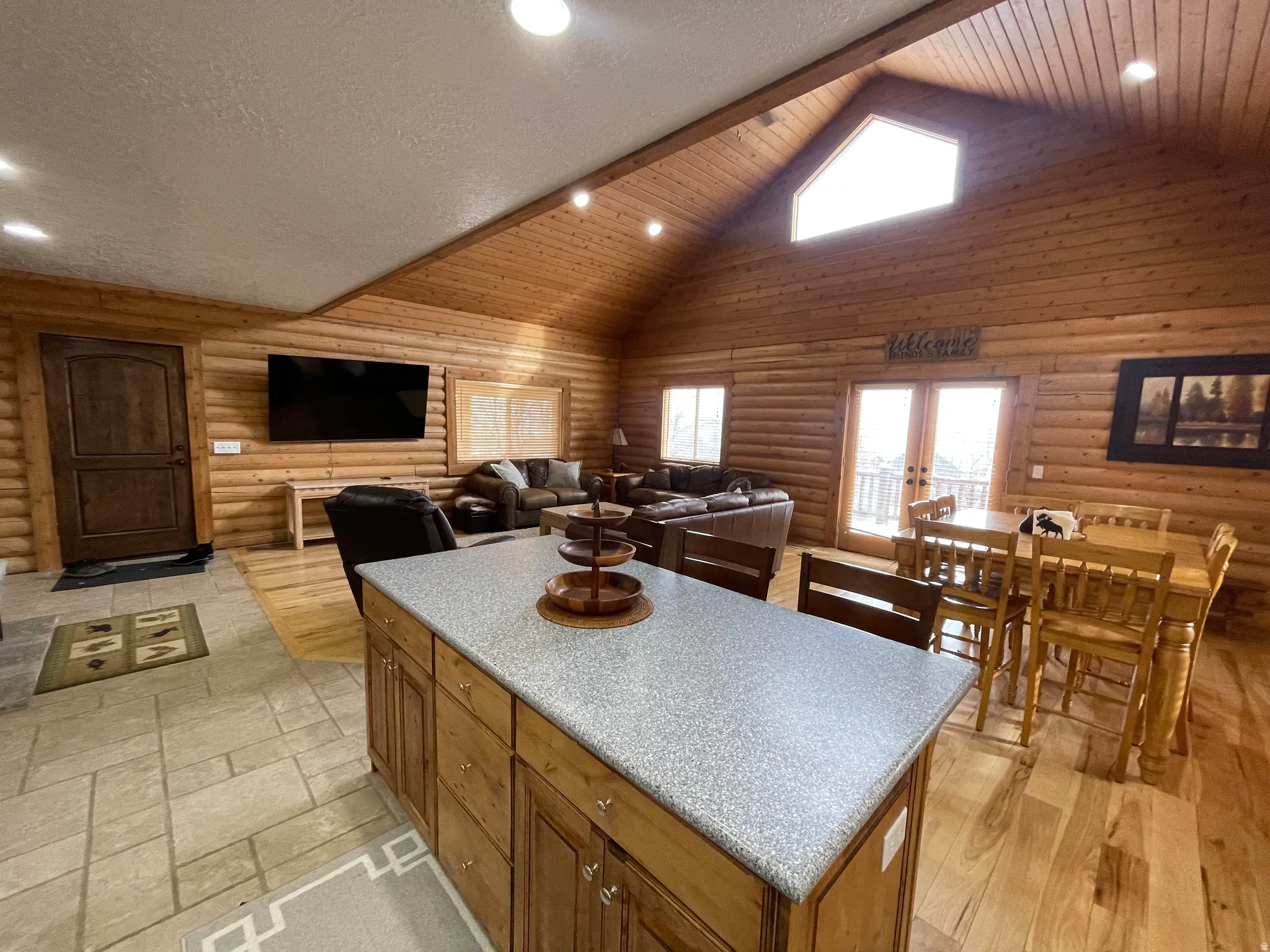 Kitchen featuring a center island, wood finish cabinets, rustic walls, recessed lighting, and open floor plan