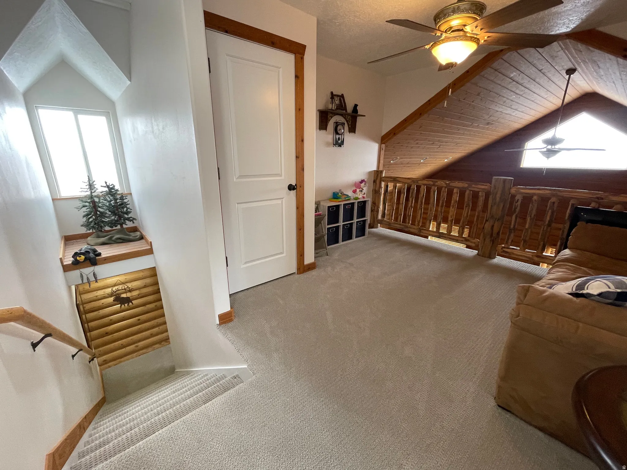 Additional living space featuring ceiling fan, light carpet, and wooden ceiling