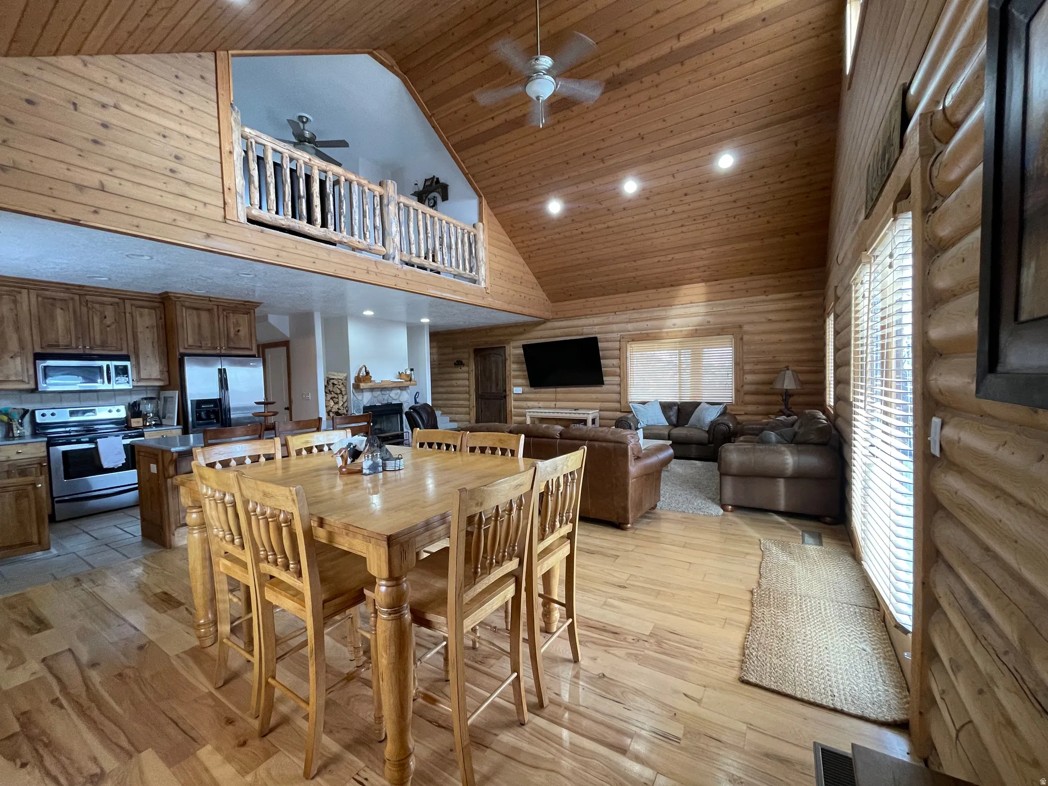 Dining area featuring log walls, a vaulted wood ceiling, a ceiling fan, recessed lighting, and light wood-style flooring
