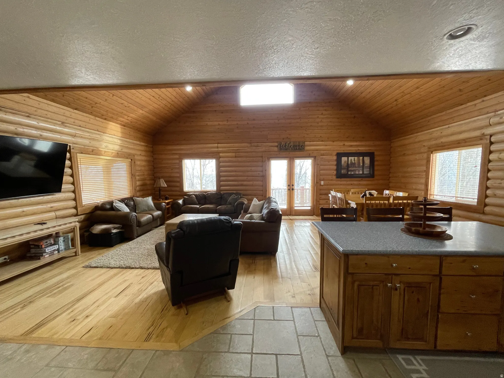 Living area with wood ceiling, french doors, light wood-style flooring, rustic walls, and recessed lighting