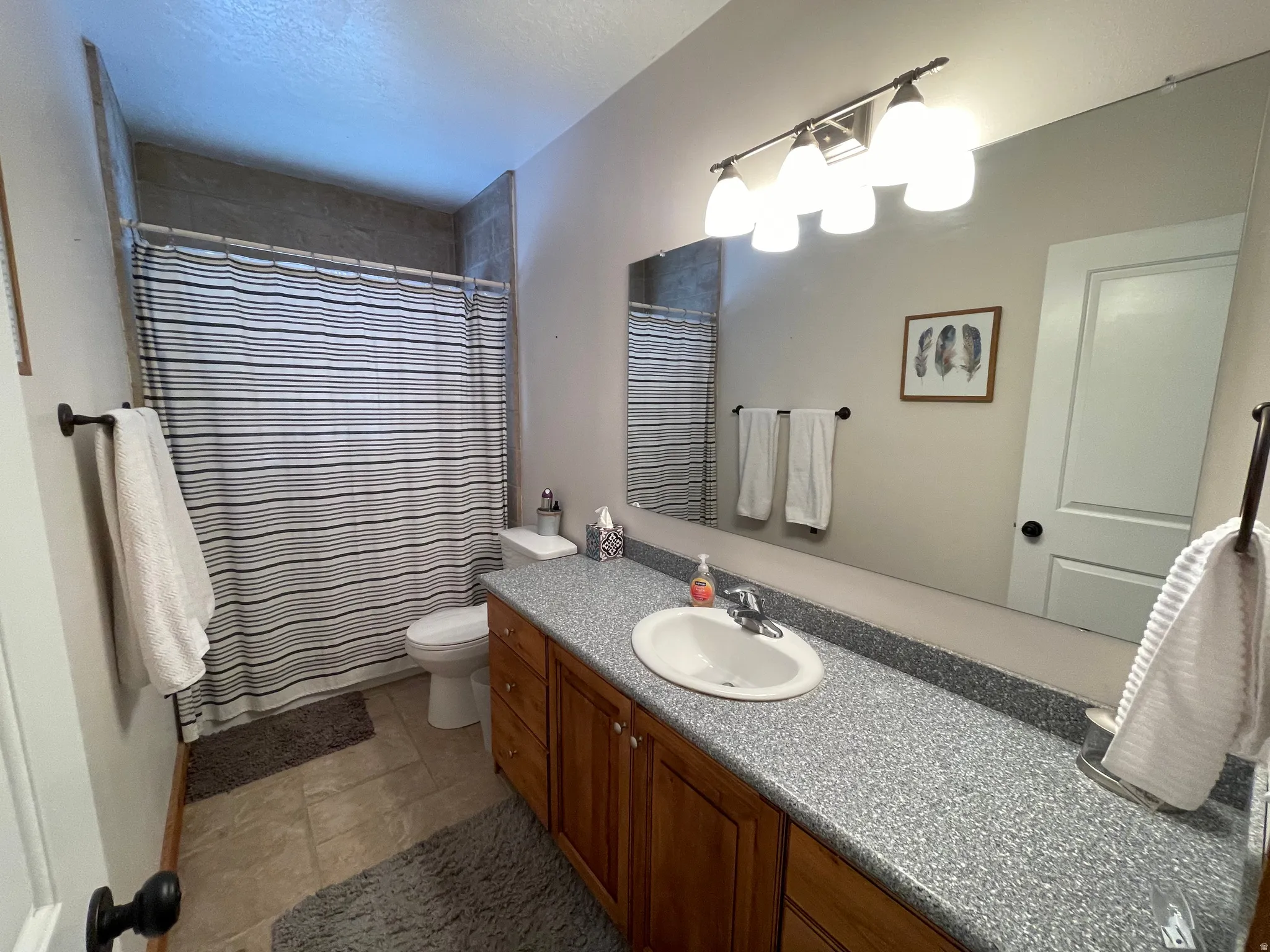 Full bath featuring vanity, a shower with curtain, and a textured ceiling