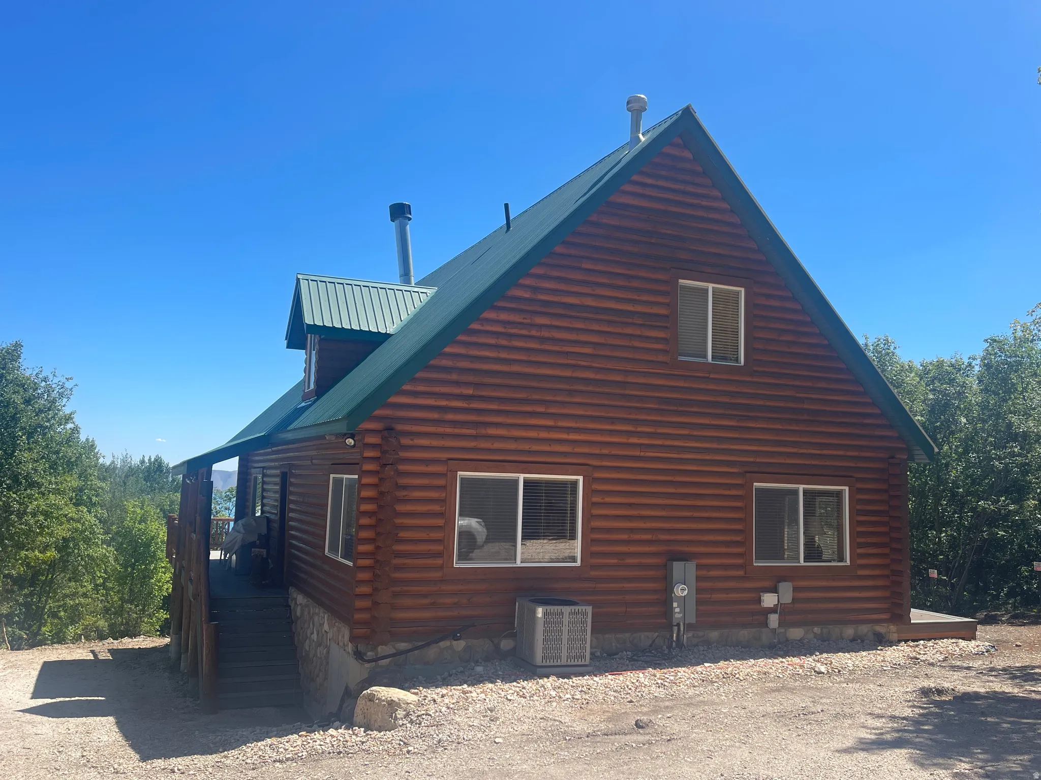 View of home's exterior with log siding and a metal roof