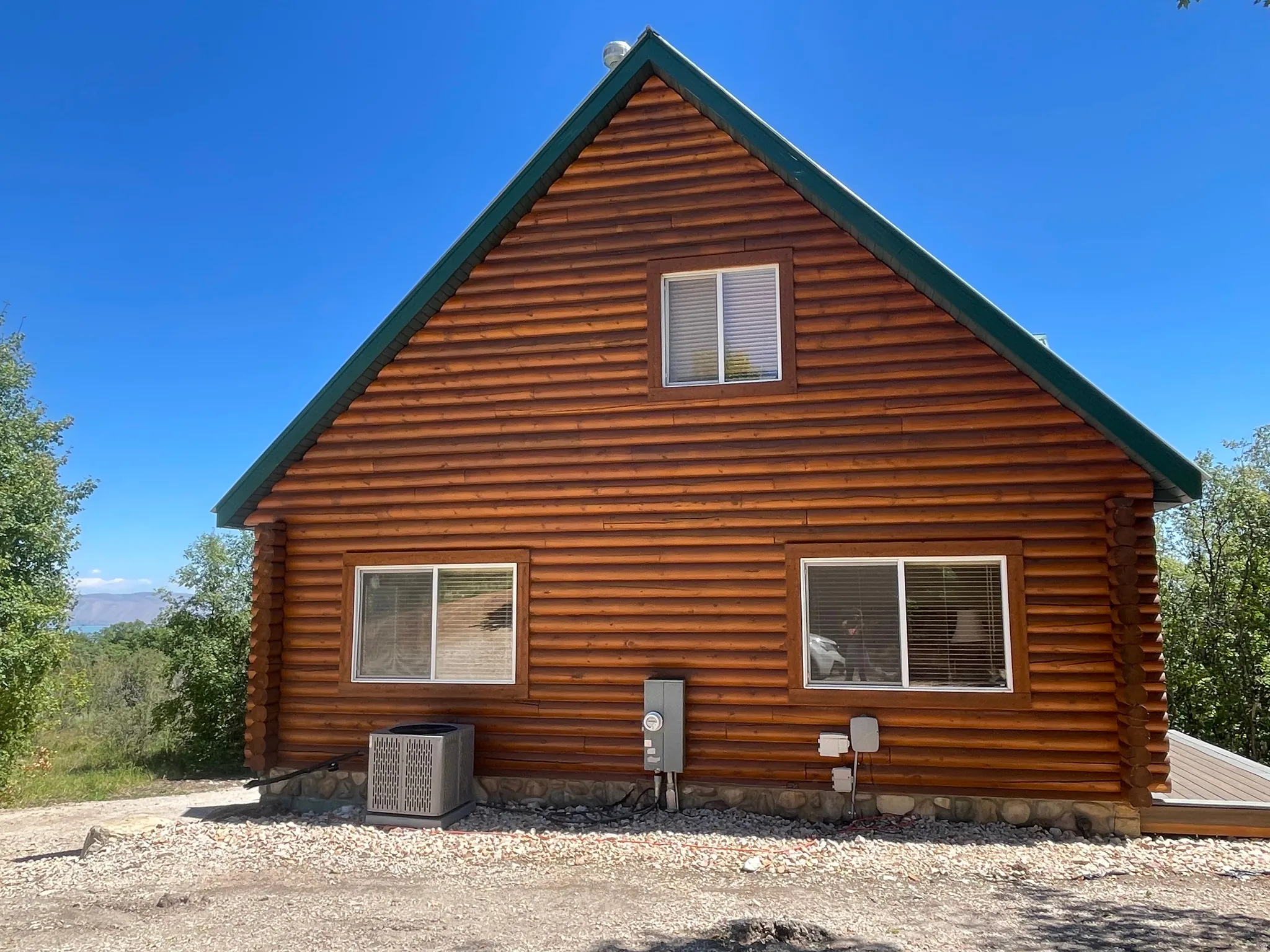 View of property exterior with a central AC unit and log siding