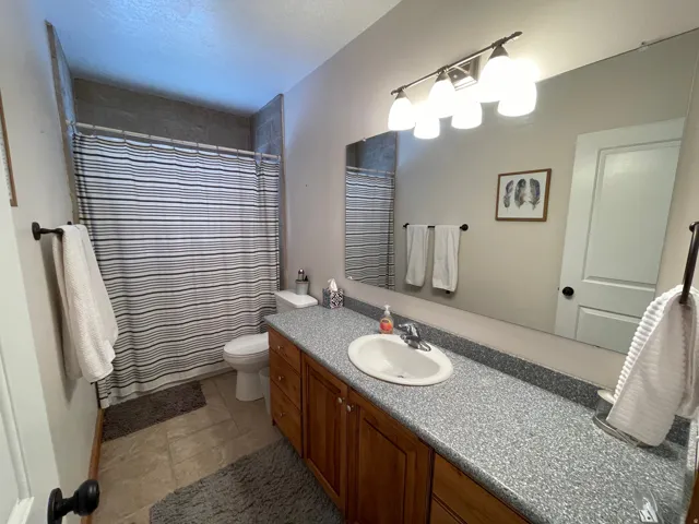Full bath featuring vanity, a shower with curtain, and a textured ceiling