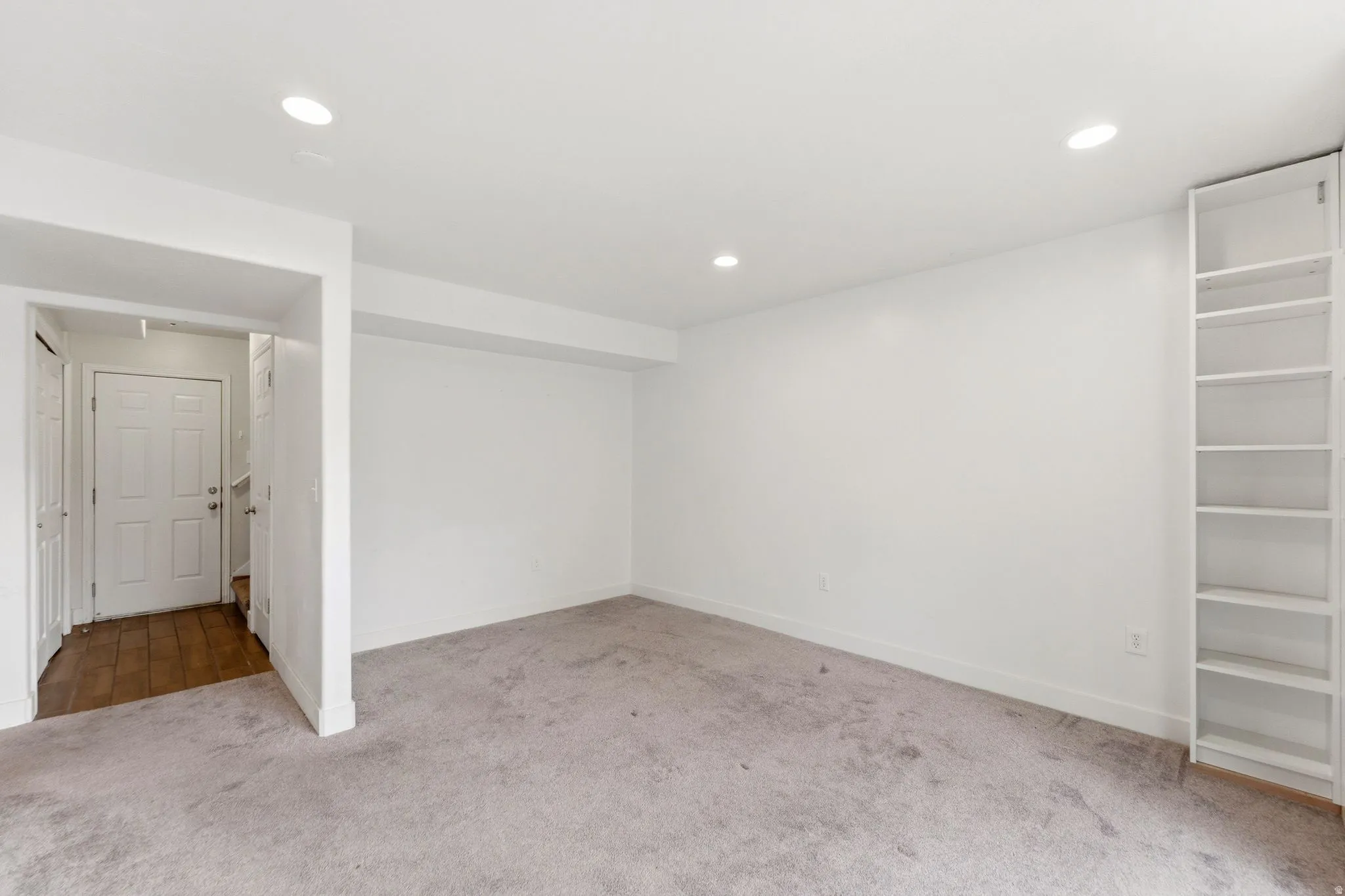 Basement with light carpet and recessed lighting
