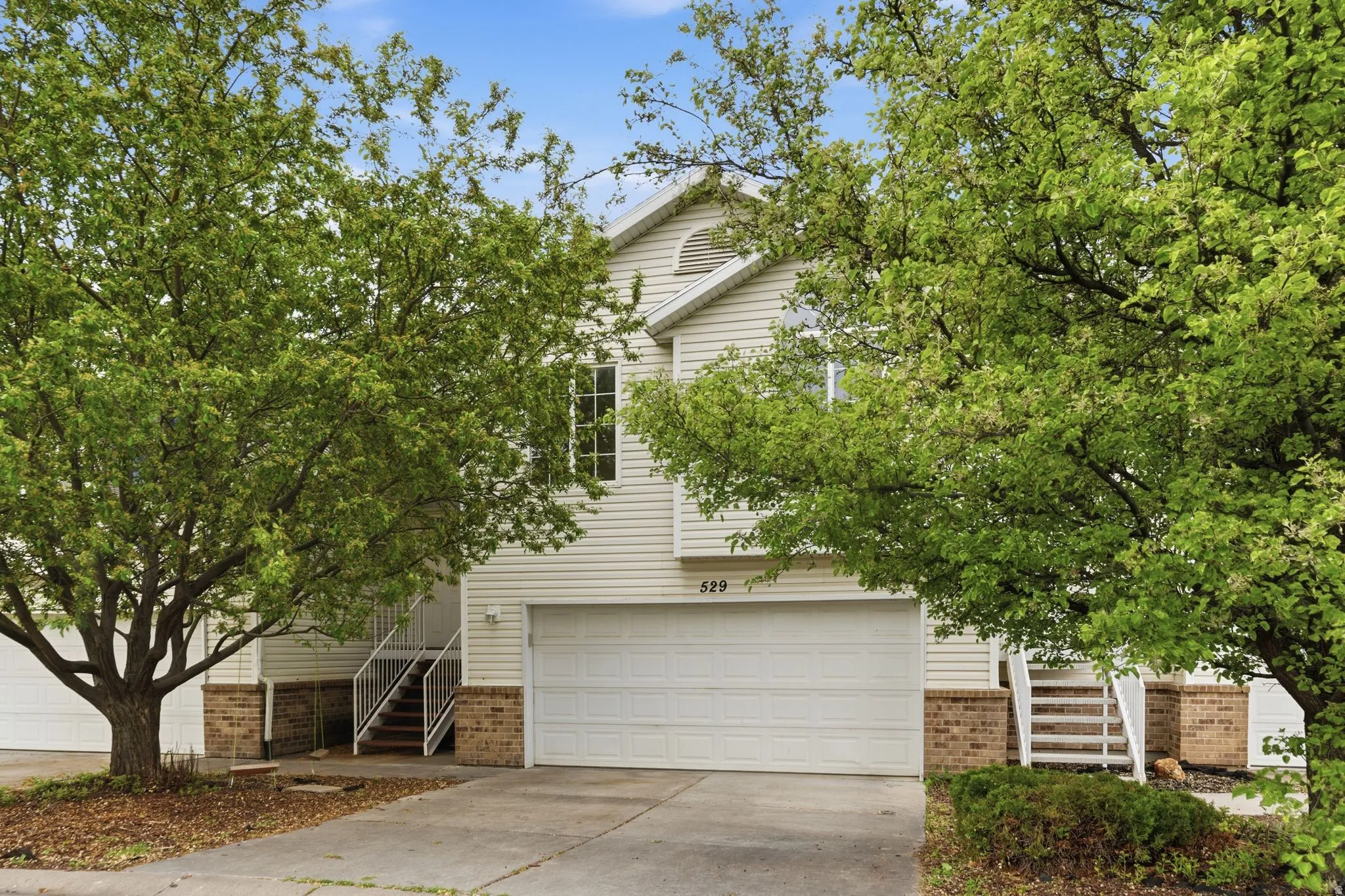Obstructed view of property with brick siding, concrete driveway, and a garage