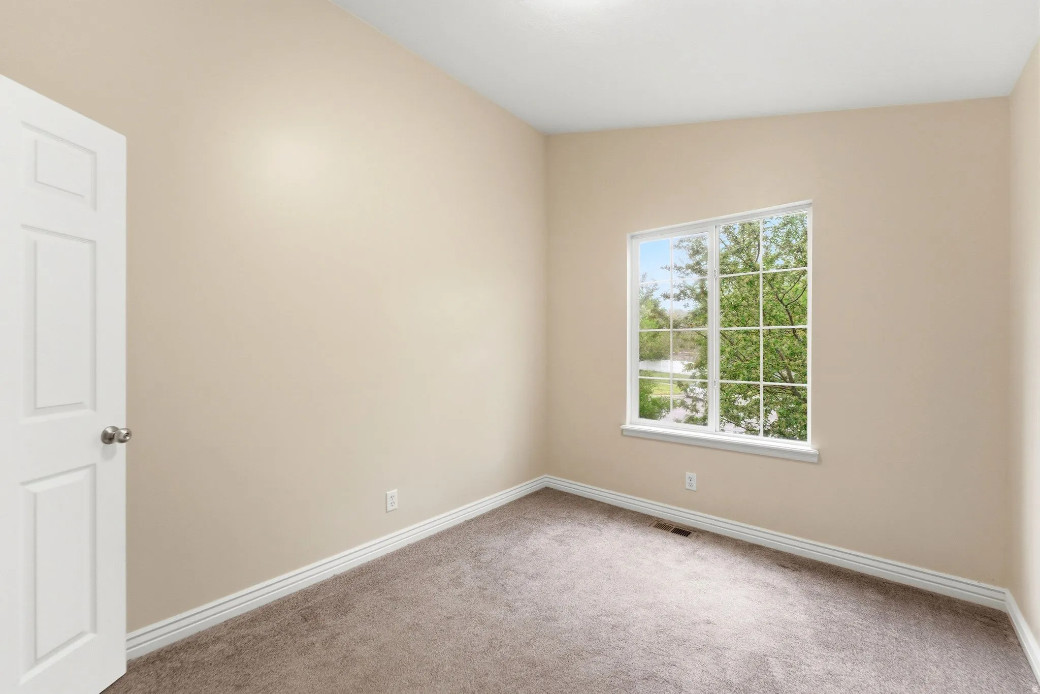 Empty room featuring baseboards and light carpet