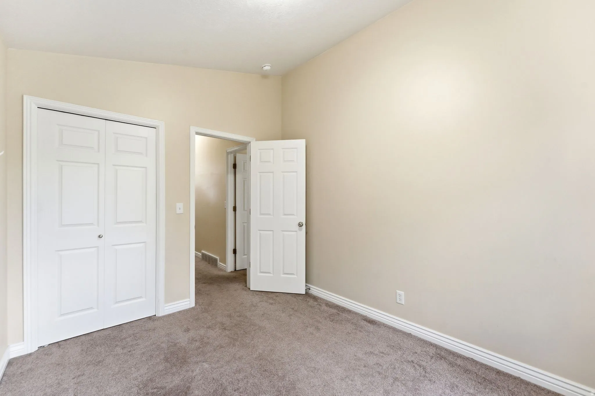 Unfurnished bedroom with light colored carpet and a closet