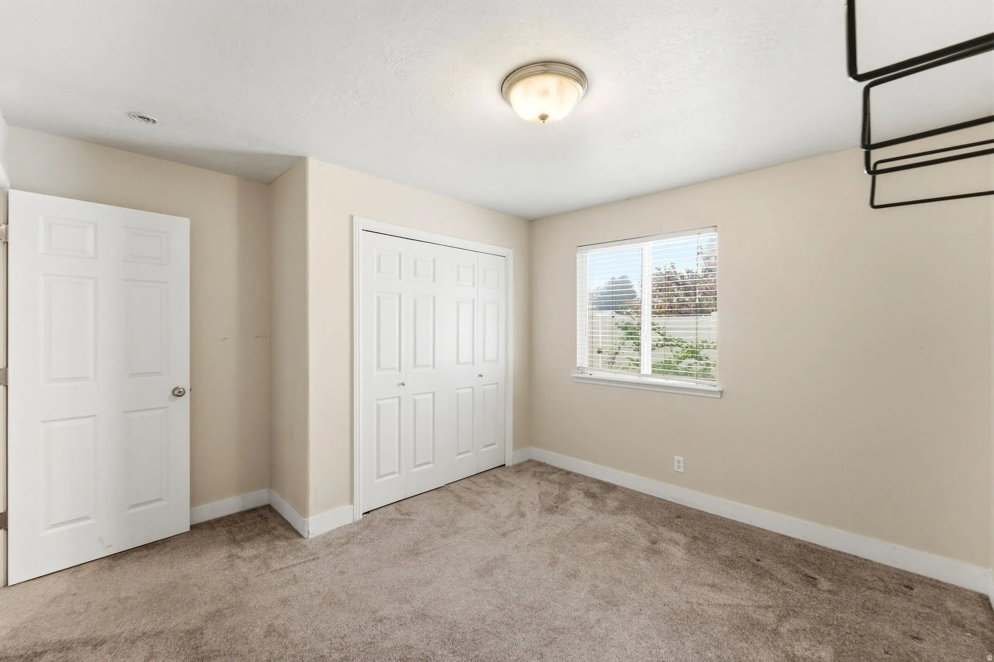 Unfurnished bedroom featuring light colored carpet and a closet