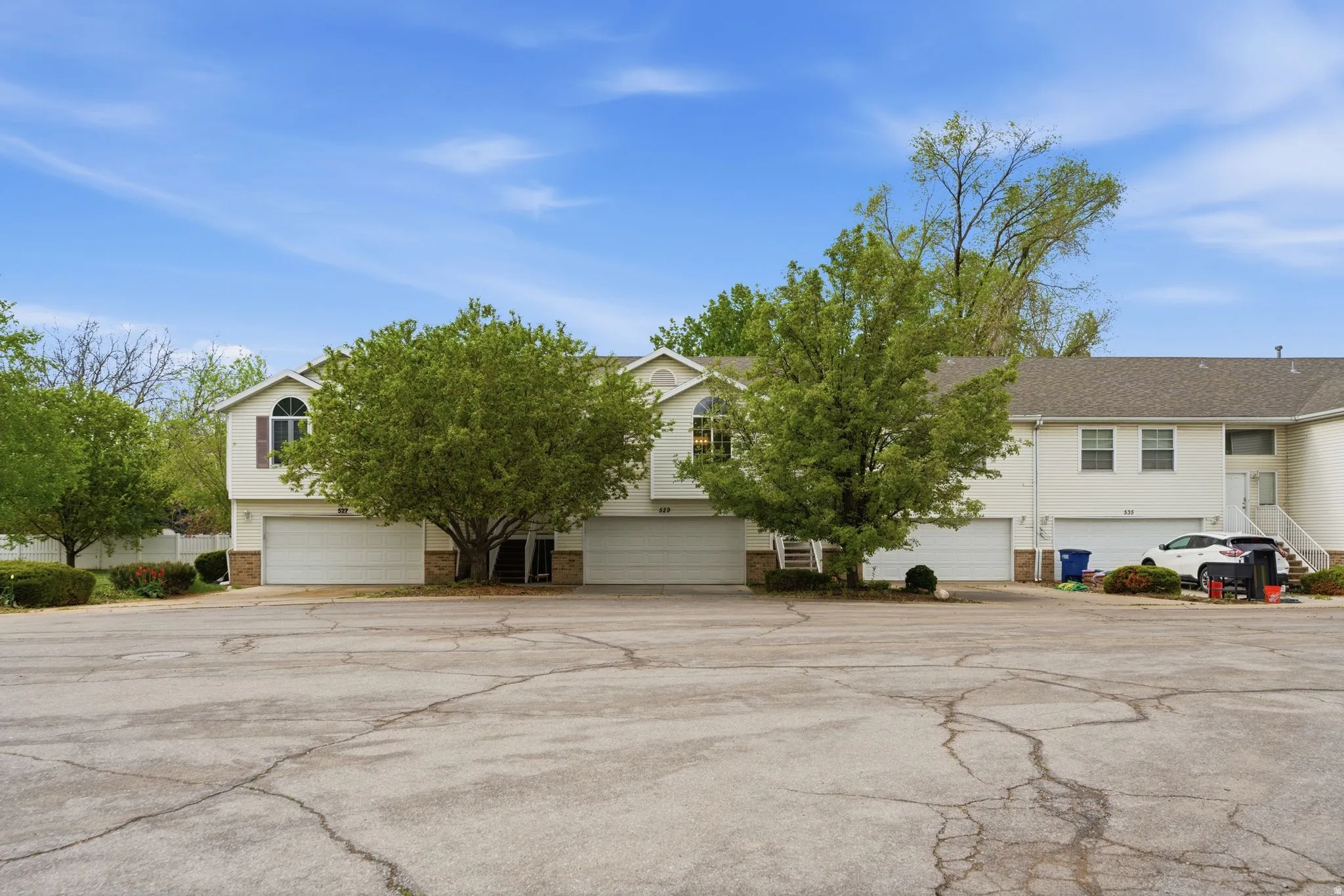 View of front of house with brick siding, an attached garage, driveway, and a residential view