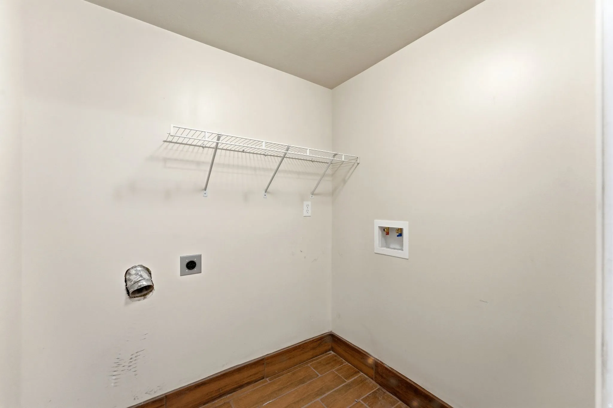 Laundry room featuring wood tiled floors, hookup for an electric dryer, and hookup for a washing machine