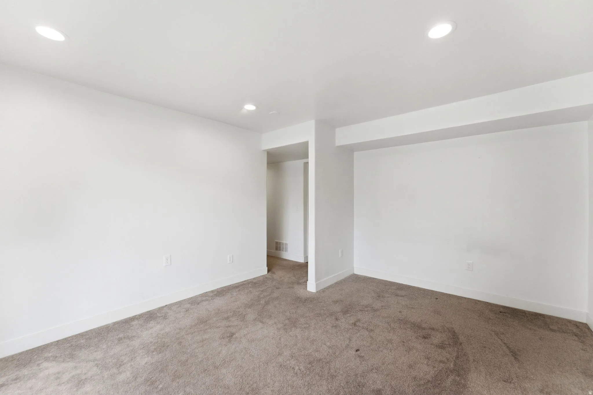 Carpeted empty room with baseboards and recessed lighting