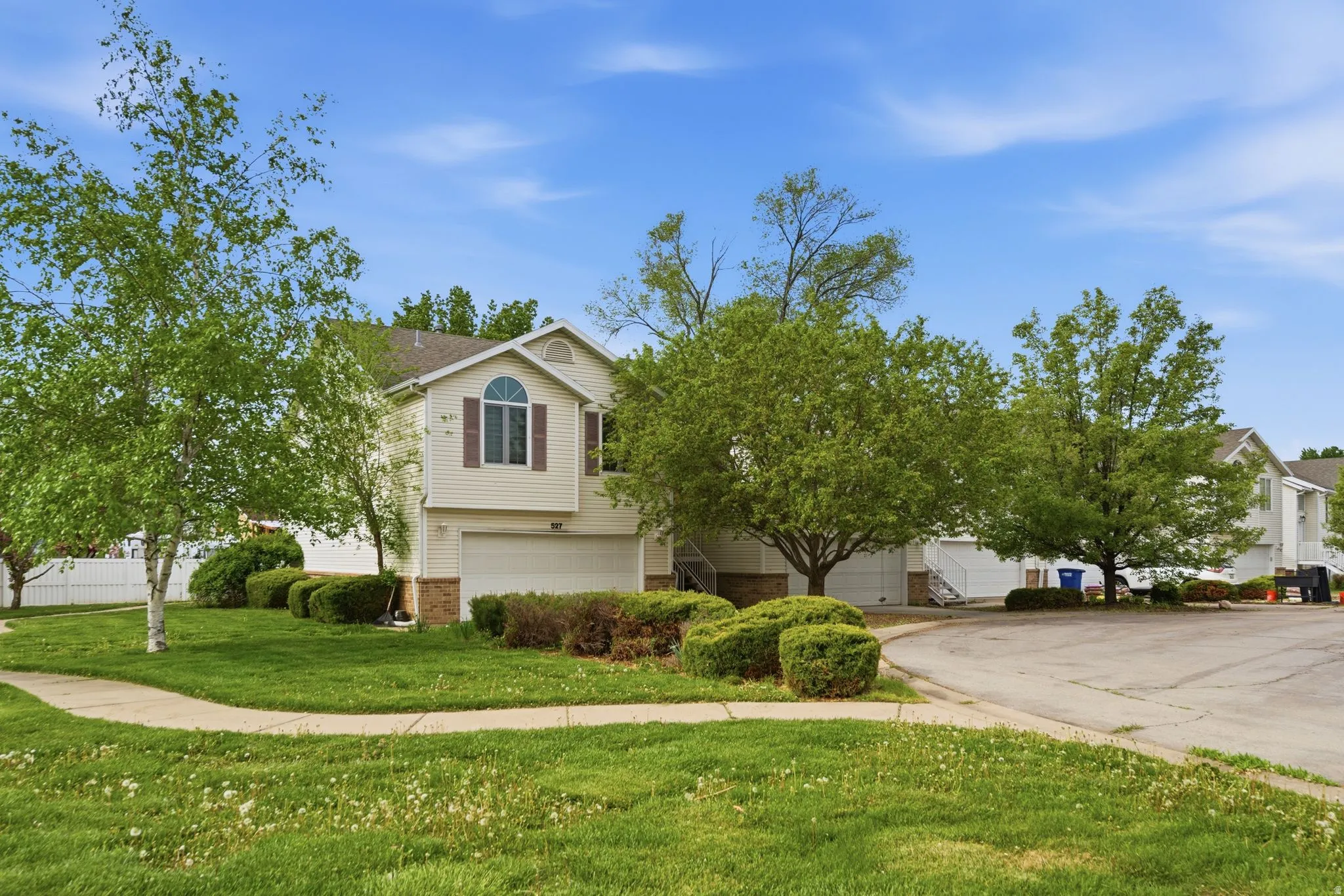 View of front of home with brick siding, a front lawn, an attached garage, and driveway