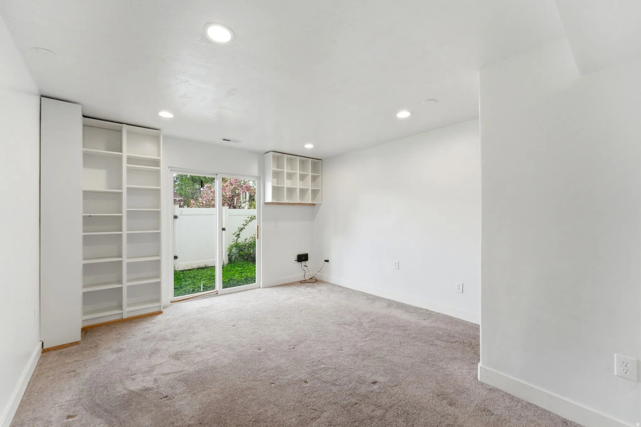 Empty room with recessed lighting and light colored carpet