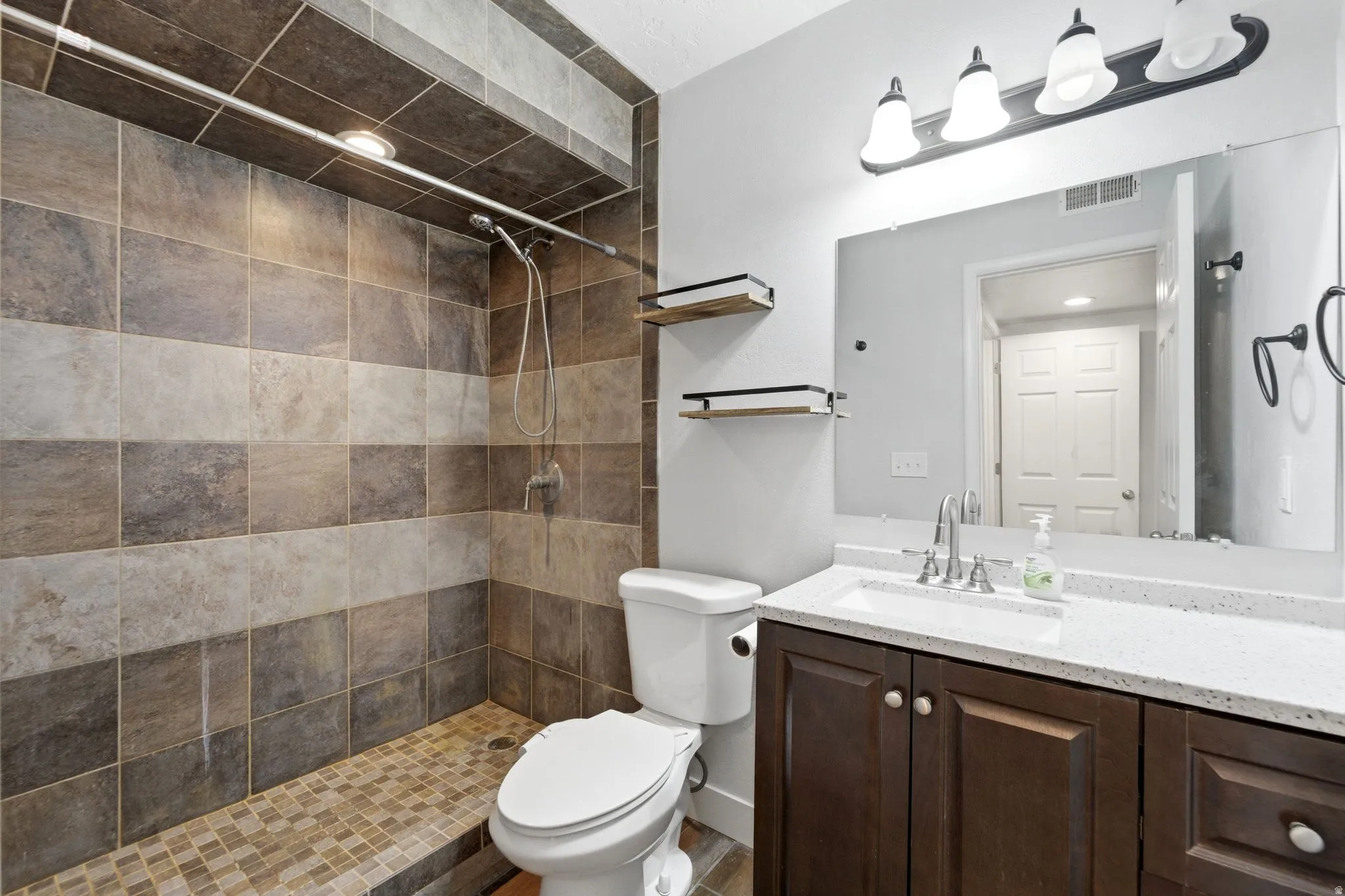 Full bathroom featuring vanity and a tile shower