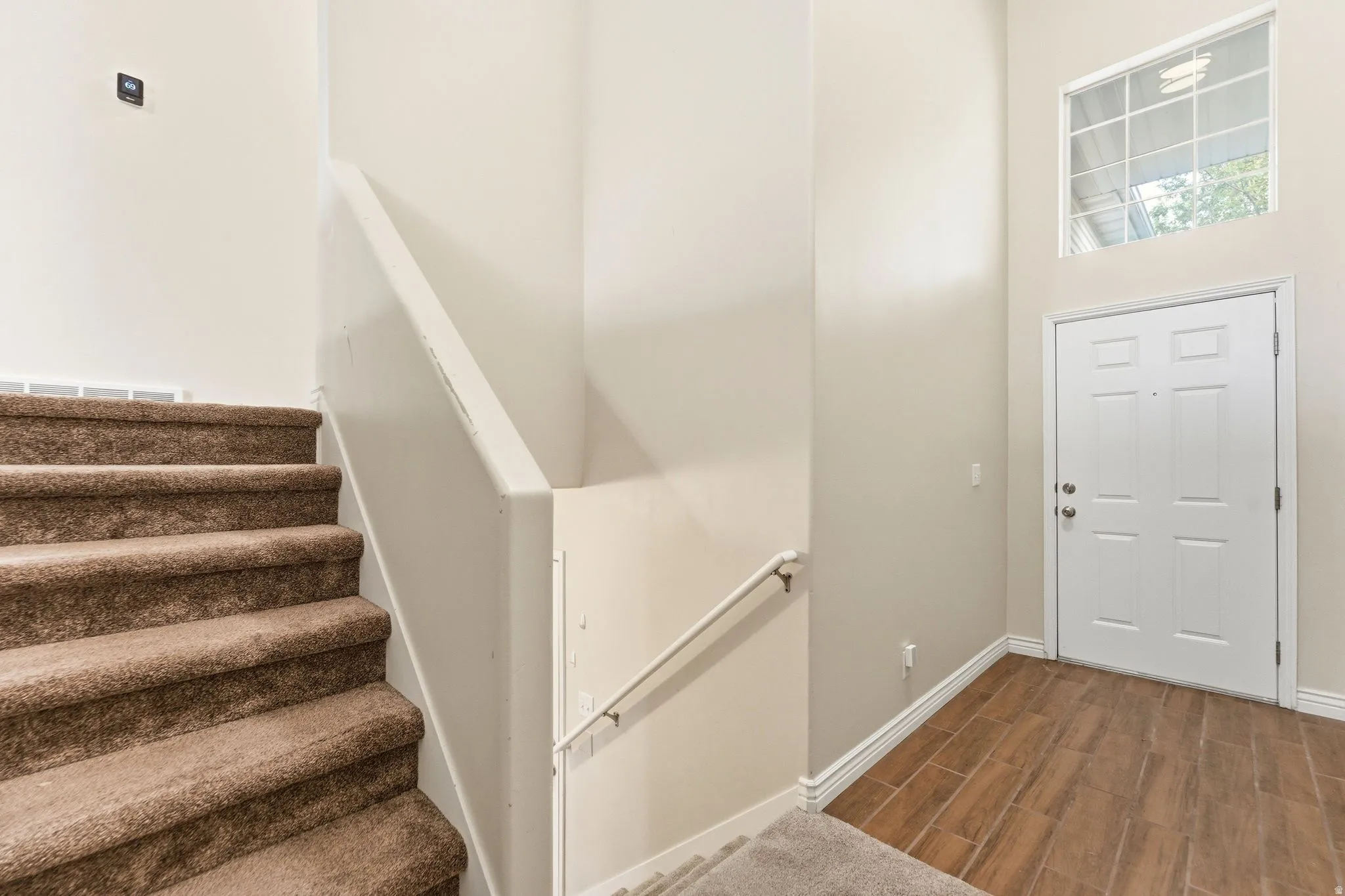 Entryway featuring wood finish floors and a high ceiling