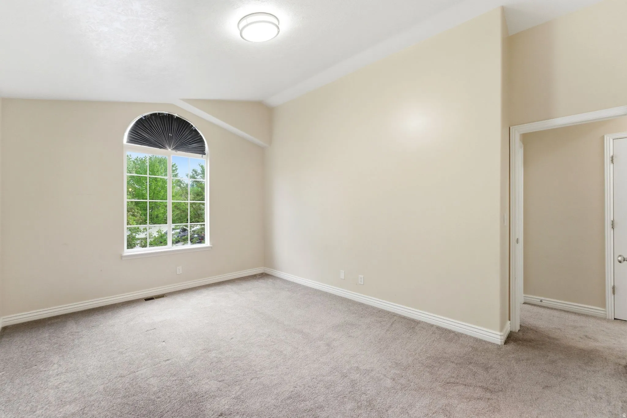 Empty room with light carpet and baseboards
