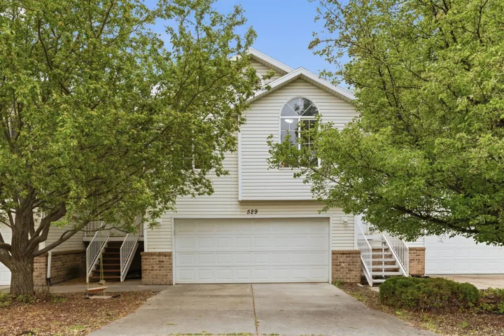 Obstructed view of property featuring brick siding, driveway, and an attached garage