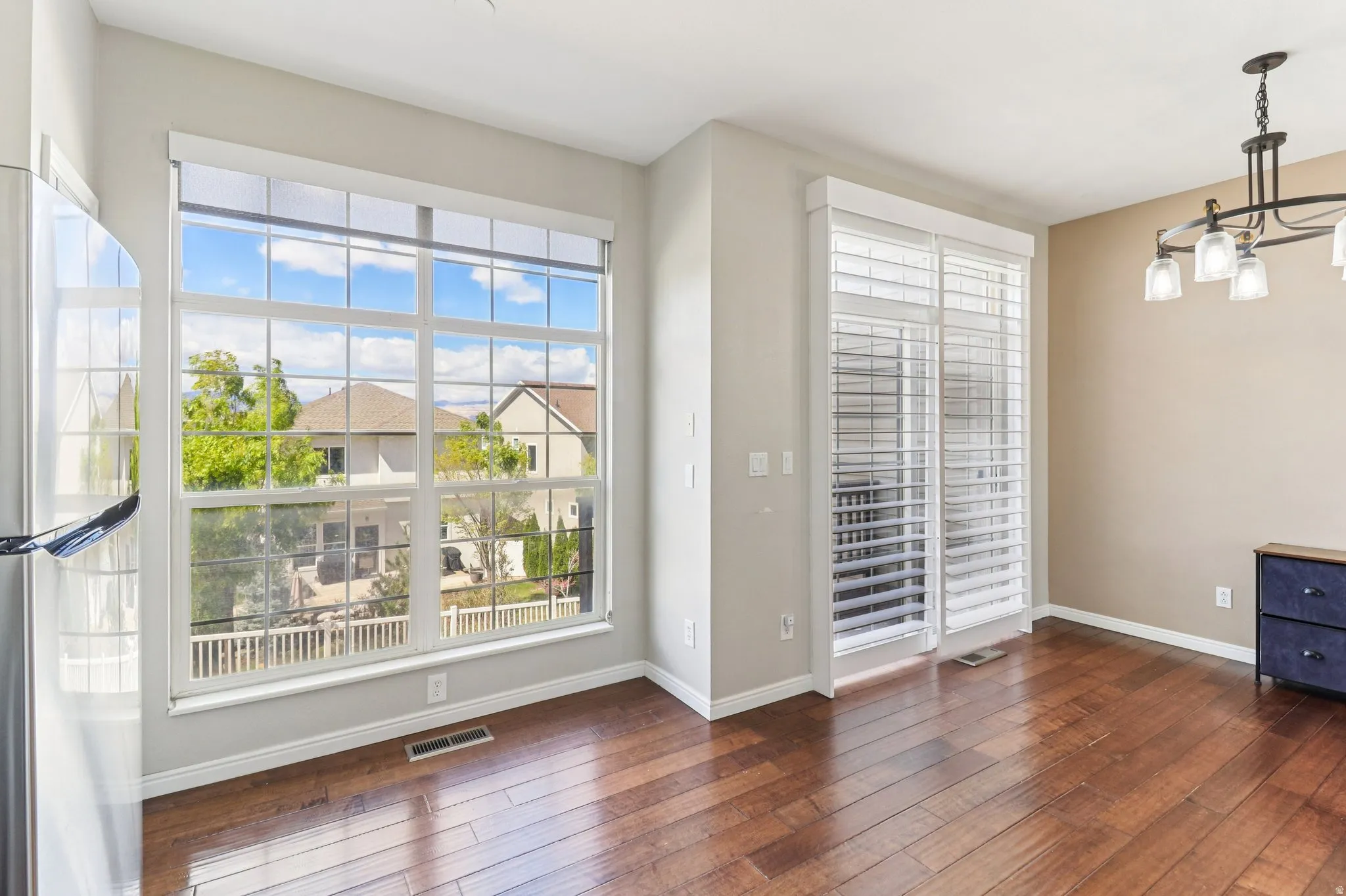 Unfurnished dining area featuring dark wood finished floors and a chandelier