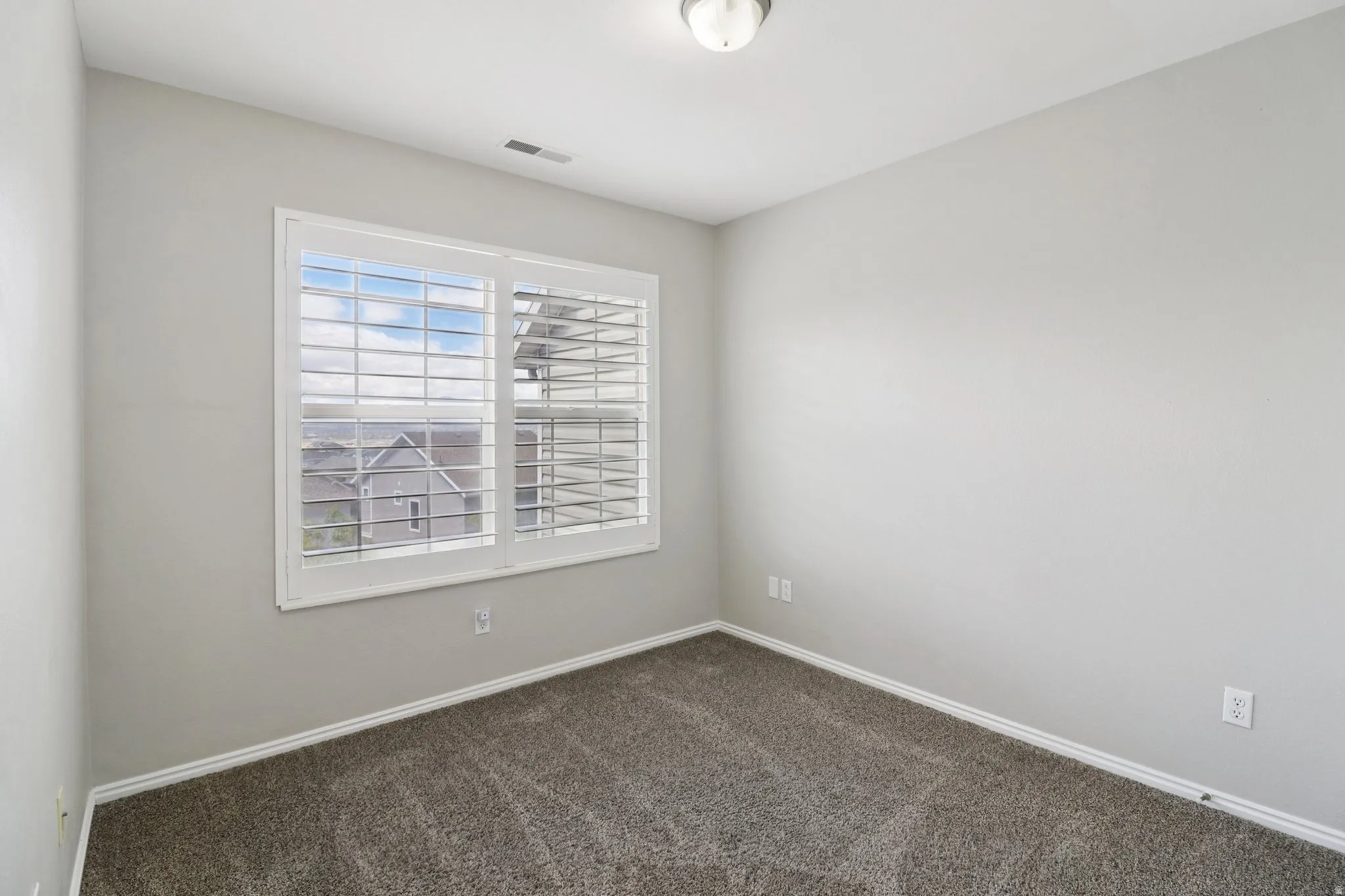 Unfurnished room with baseboards and dark colored carpet