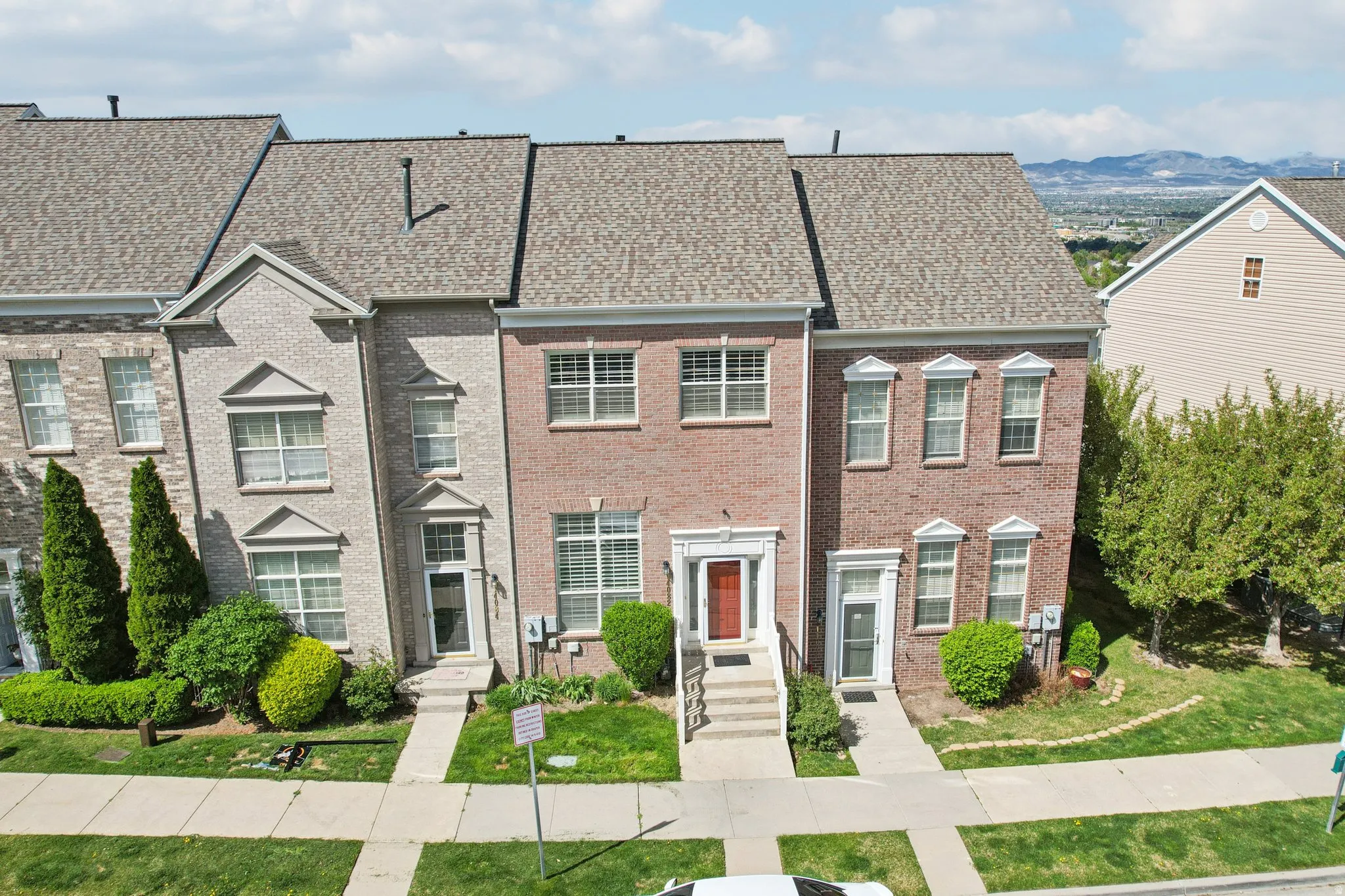 Colonial-style house featuring brick siding, a shingled roof, and a residential view