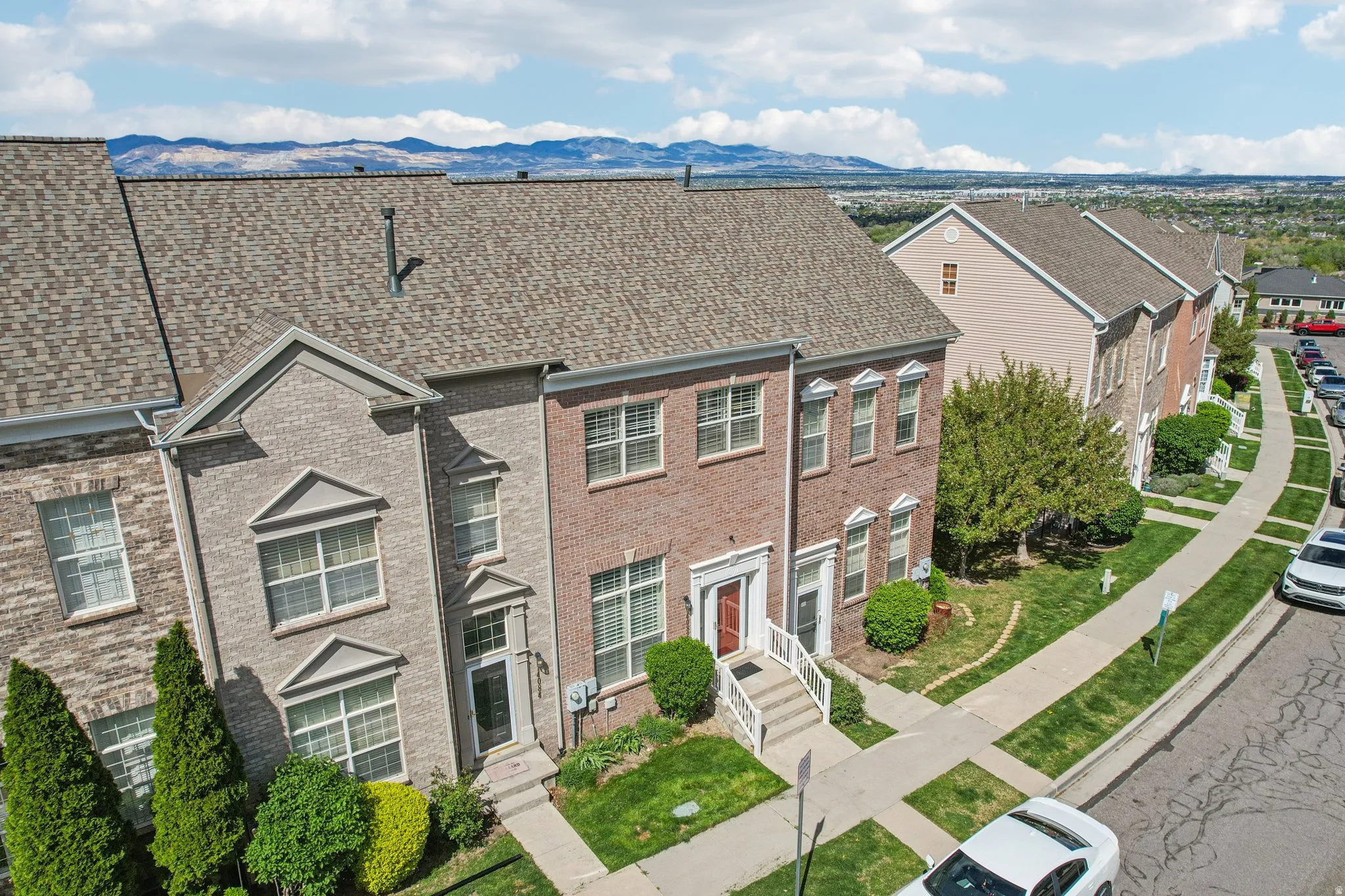 View of front facade featuring roof with shingles, brick siding, and a mountain view