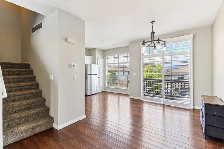 Unfurnished dining area with a chandelier and dark wood-style floors