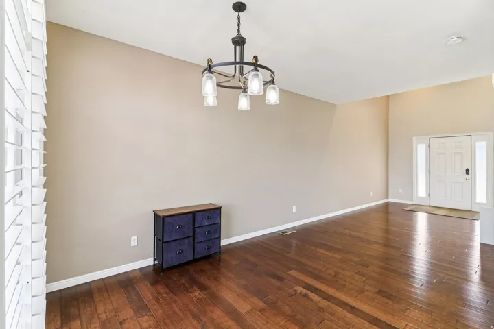 Unfurnished dining area featuring a chandelier and dark wood-style flooring